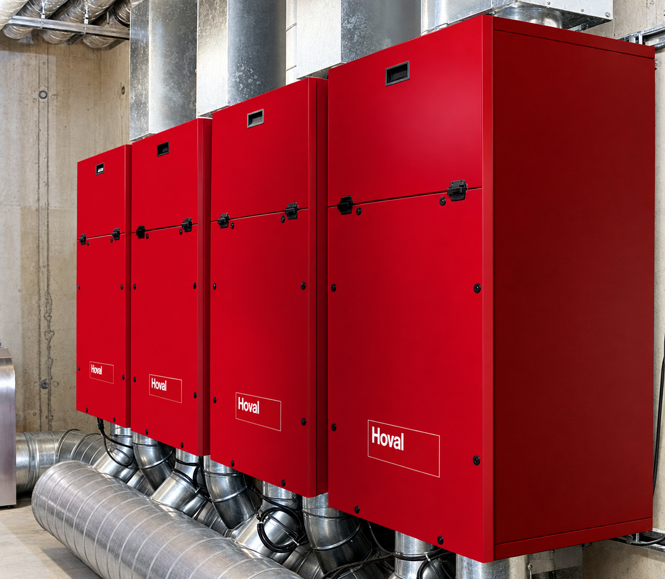 Apparecchiature Hoval rosse collegate a canalizzazioni metalliche in un locale tecnico