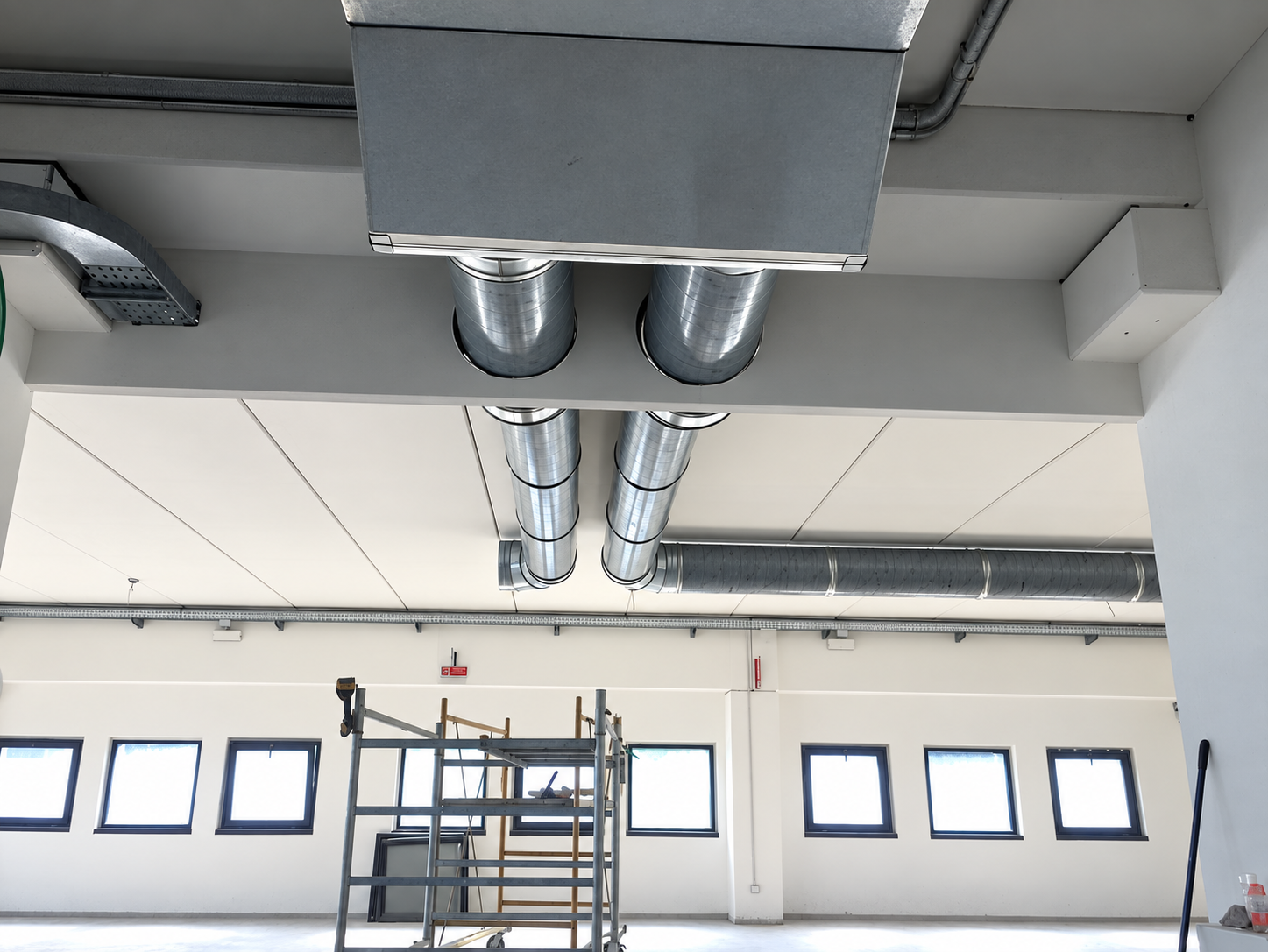 Condotte di ventilazione in acciaio installate a soffitto in un ambiente industriale
